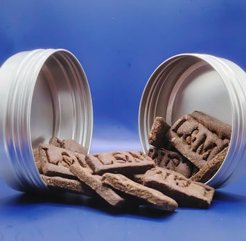 a dog treat in a container with a dog treat with a blue plan loumat
