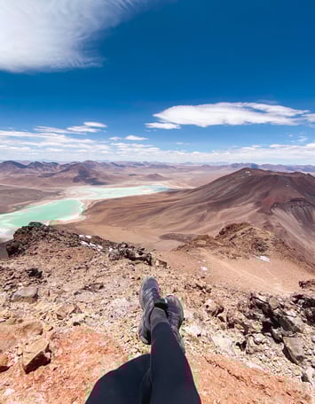 View from the summit of Licancabur volcano showing my legs, another volcano, and Laguna Verde.