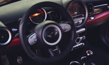 a car dashboard with a steering wheel and dashboard controls