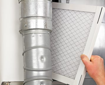 a person holding a duct with a air filter