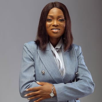 An image of a woman in grey suit, smiling.