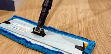 Technicien de M & M Services Pro passant la serpillière bleue dans un local professionnel à Rouen