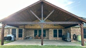 Larged covered patio with a vaulted wooden ceiling.