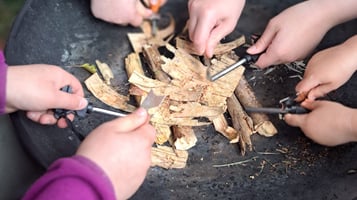 a group of children's hands learning to light fires