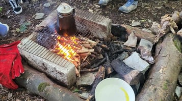 a group of people sitting around a camp fire 