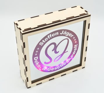 Holzkasten mit einem Spiegel, auf dem Spiegel ist das Logo dieser Webseite vorhanden, Lila beleuchte