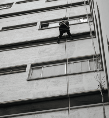 a teddy bear climbing up a tall building