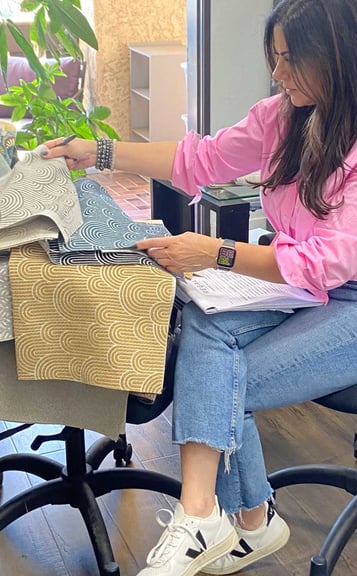 Sigal, founder of Solo Home Decor, selects fabrics while designing custom furniture.