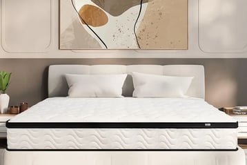 a bed with a white bed and a painting on the wall