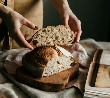 a person holding a piece of bread in their hand