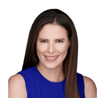 a pretty woman with brown hair and brown eyes in a blue dress smiling at the camera.