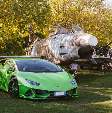 Lamborghini verde affianco a un caccia militare