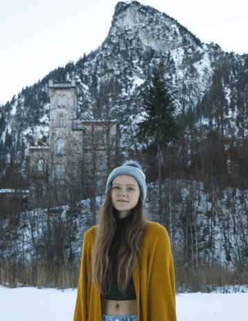 Girl standing in front of a castle in Oberammergau, Germany in the winter