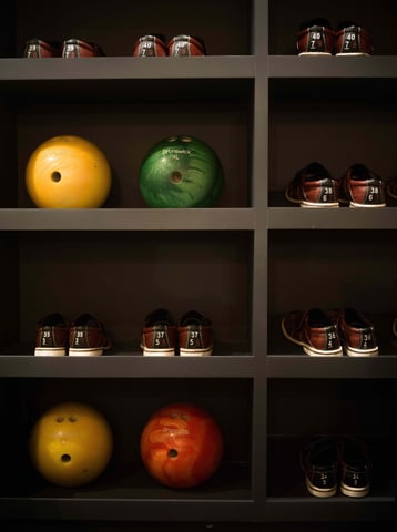 Bowling balls and shoes organized on shelves in the private bowling alley at Villa La Gratitud.