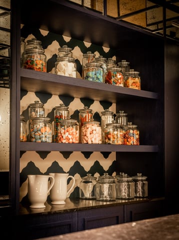 Candy shelf at Villa La Gratitud, with glass jars filled with colorful sweets and classic treats.