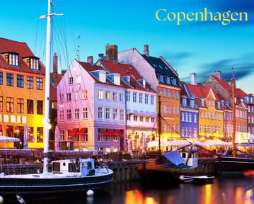 a boat in the water with a city of Copenhagen in the background