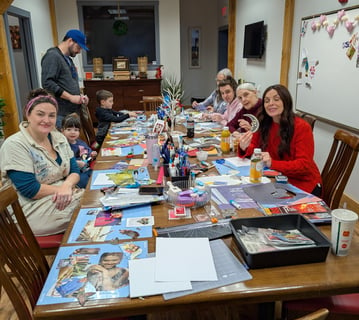 a group of adults and children sitting around a table making collages