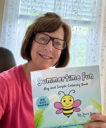 Photo of Laura Kane holding the Summertime Fun coloring book