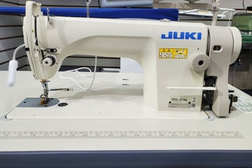 a sewing machine with a blue and white background