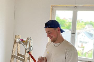 a man in a white shirt and a ladder