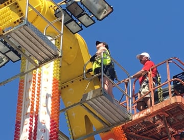 a woman inspector on a lifter at a carnival ride