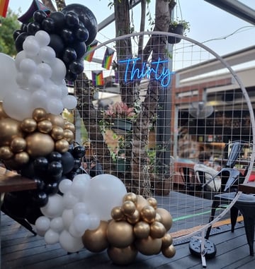 Circle backdrop, Thirty neon, gold black and white garland at 30th birthday at Brunswick Hotel.