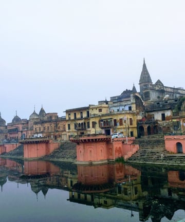 a river with a bridge and buildings in the background