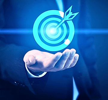 A businessman in a suit holds up a holographic image of a dart hitting a bullseye target, face unseen.