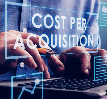 Man in blue shirt types on a laptop, with the holographic words "Cost Per Acquisition" emerging from the screen, face unseen.