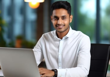 a young hindu working professional sitting at a desk with a laptop