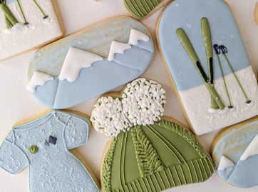 Cookies of onesies, hats, skis, and mountains for a baby shower