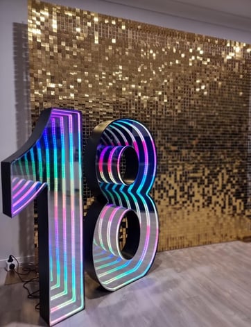 18 marquee number in front of a gold shimmer wall getting ready for an 18th birthday in Brisbane.