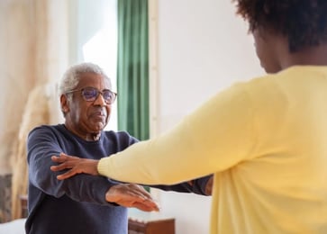 An older man and woman are joyfully dancing together, showcasing their connection and enjoyment of t