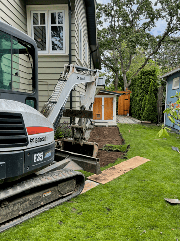 a construction worker is working on a house with bobcat excavator