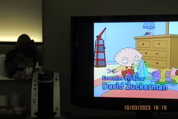 Girl sitting on a bed in the mirror watching cartoons