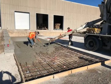 a man is pouring concrete into a concrete slab