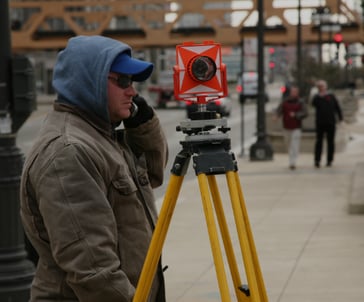 a man in a blue jacket and a camera on a tripod