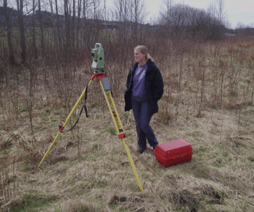 a woman in a field with a tripod and a tripod