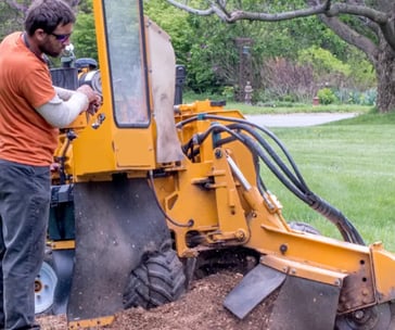 a man is standing in the dirt with a machine