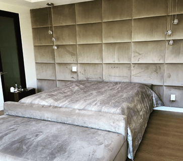 Upholstered bed with velvet wall panels in a modern bedroom by Solo Home Decor.
