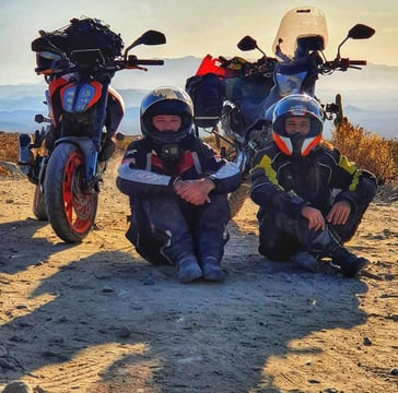 a group of people sitting on top of a dirt road