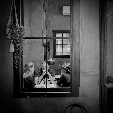 Peter Pickering's lens spots 3 people sitting at a table viewed through a window