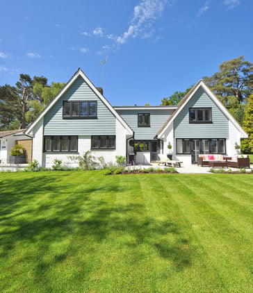 a house with a great lawn surrounding an outdoor patio