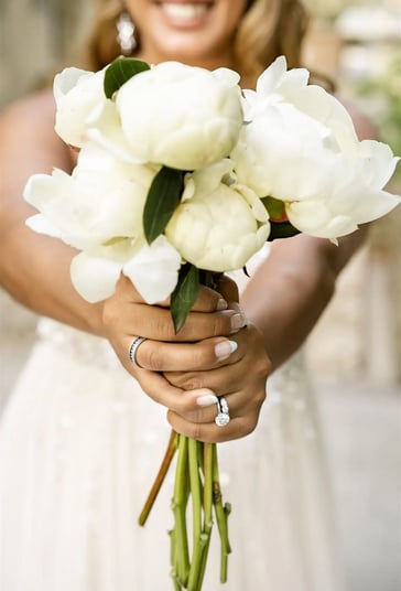 Bridal bouquet close-up with bride blurred in background — South of France wedding photography cost