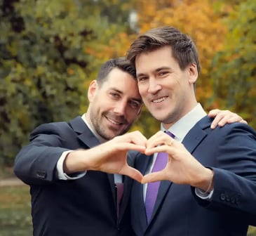 "Pareja gay casada en España, formando un corazón con las manos y celebrando su amor y boda."