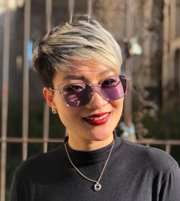 a woman with short hair and sunglasses on a fence