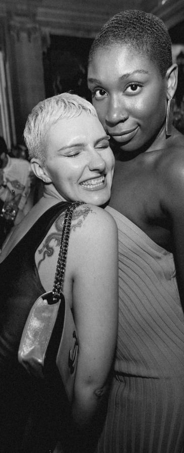 Two elegantly dressed women posing for a photograph in the luxurious interior of a private members c