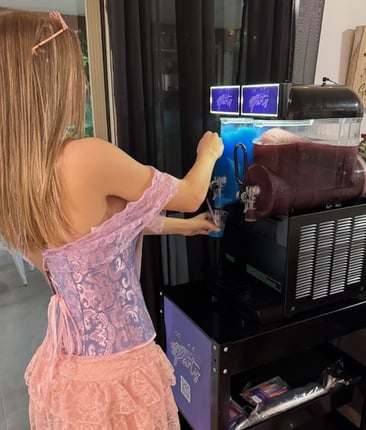 Liv pouring a cup of blue raspberry slushie from the SweetAz Co. slushie machine at her 16th birthday in Mount Cotton.