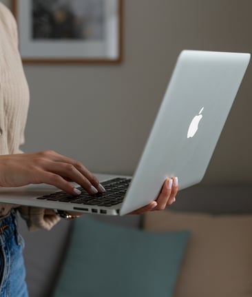 female business coach typing on Apple laptop