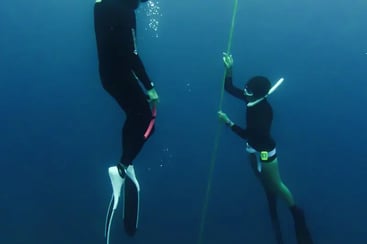 a man and woman freedive training line session
